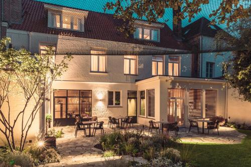 a house with a patio with tables and chairs at Raphaëlles Boutique b&b in Bruges