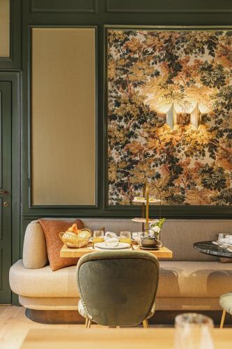 a living room with a table and a large painting at Raphaëlles Boutique b&b in Bruges