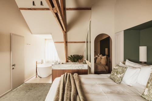 a bedroom with a large bed and a bath tub at Raphaëlles Boutique b&b in Bruges