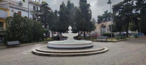 a large white fountain in the middle of a street at Piazza Vittoria Apartment in Carini