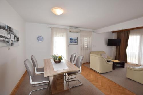 a living room with a dining room table and chairs at Apartments Danica in Primošten