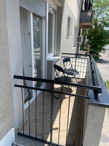 a balcony with two chairs and a table on it at FRIENDLY HOME in Tuzla