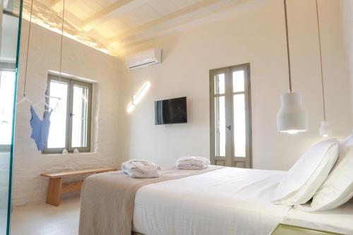 1 dormitorio blanco con 1 cama grande y ventanas en VILLA CALLIOPE KEA, en Ioulida