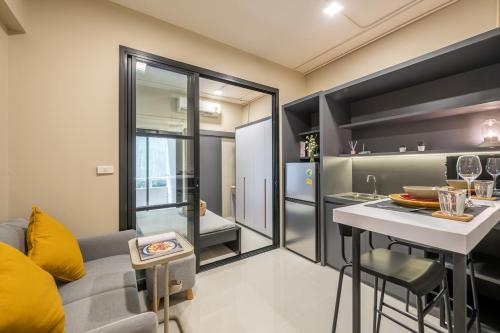 a living room with a kitchen and a table with a counter at C2 stay Phayathai in Pom Prap