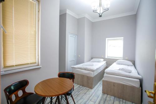 a room with two beds and a table and chairs at city point in Kutaisi