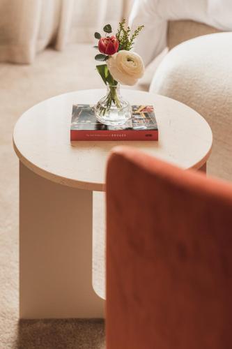 a table with a vase of flowers on it at Raphaëlles Boutique b&b in Bruges