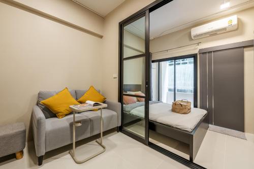 a small room with a couch and a mirror at C2 stay Phayathai in Pom Prap