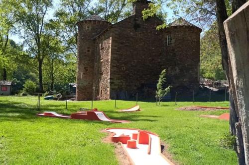 un antiguo castillo con un parque infantil delante de él en Chalet climatisé en bordure de rivière mansardée, en Trébas
