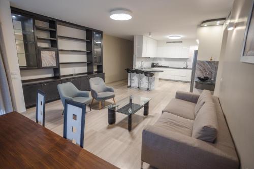 a living room with a couch and chairs and a kitchen at Luxury apartments Boutique Haneviim in Jerusalem