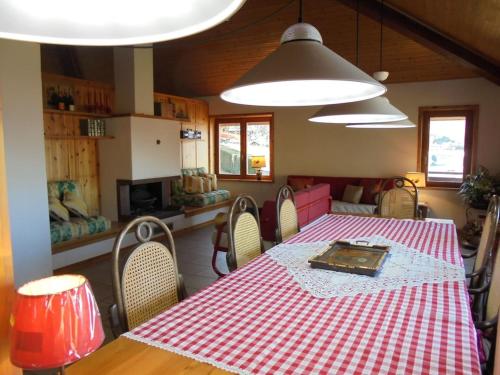 een eetkamer met een rode en witte tafel en stoelen bij La Mosa - Villa ai Prati di Cavedago, nel comprensorio del parco Adamello-Brenta in Cavedago