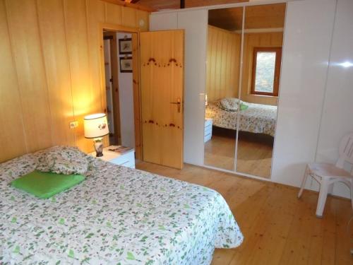 1 dormitorio con cama y espejo en La Mosa - Villa ai Prati di Cavedago, nel comprensorio del parco Adamello-Brenta, en Cavedago
