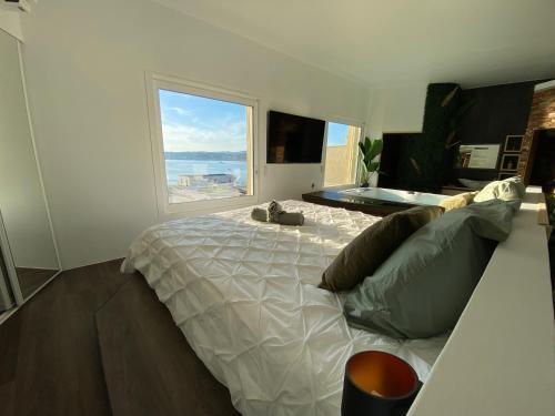 a bedroom with a large bed with a large window at Sunset in Six-Fours-les-Plages