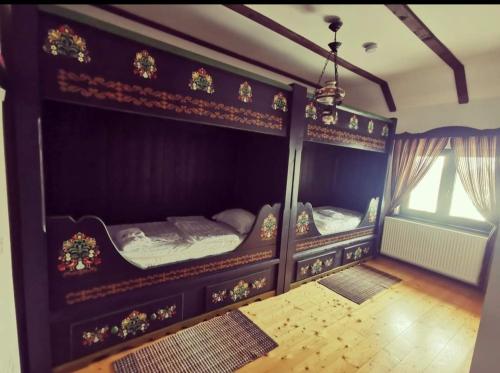 two bunk beds in a room with a window at Pensiunea Casa Moga in Bucium