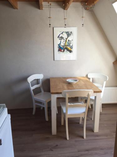 een eettafel met 2 stoelen en een tafel bij Holiday in Spakenburg t Afferhuus in Spakenburg