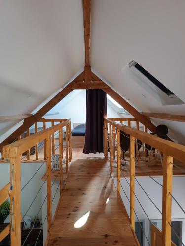 a room with a wooden floor and a ceiling at L'écurie in Méneslies