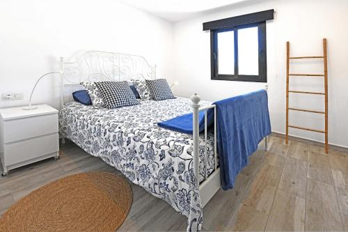 a bedroom with a bed with a blue and white comforter at Casa El Consuelo in Tijarafe
