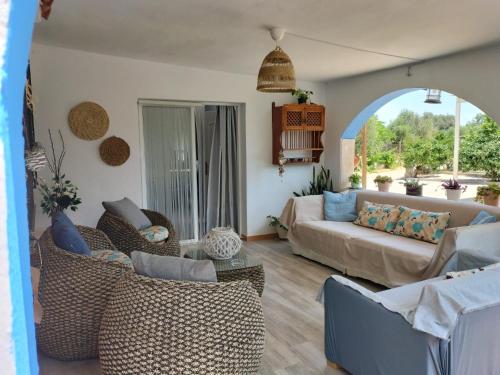 ein Wohnzimmer mit einem Sofa und Stühlen in der Unterkunft VILLA LOS ARCOS in Málaga