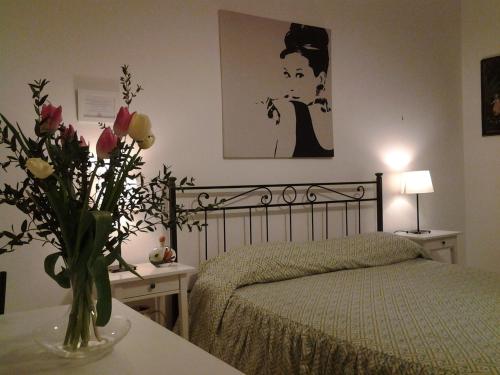 a bedroom with a bed and a vase of flowers on a table at B&B Trastevere in Bed in Rome
