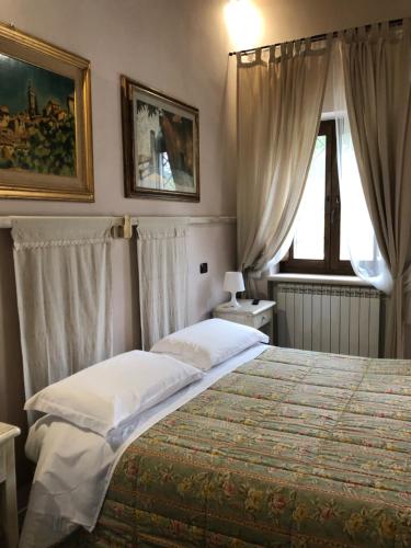 ein Schlafzimmer mit einem großen Bett und einem Fenster in der Unterkunft Il Capisterium in Norcia