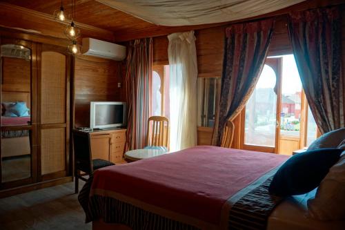 a bedroom with a bed and a tv and a window at Adel's villa in Sharm El Sheikh