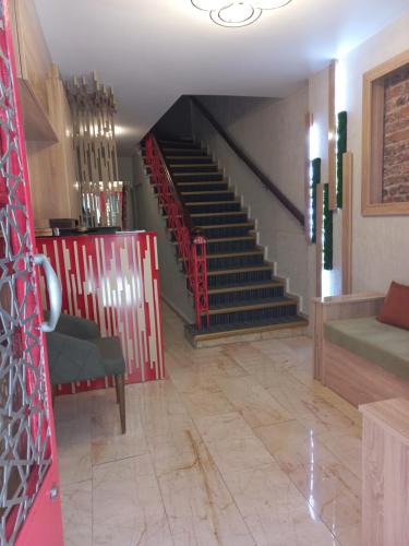 イスタンブールにあるナゲハン ホテル オールド シティの赤い椅子とソファ付きの階段のある部屋