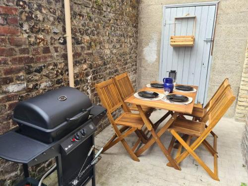 une table et des chaises à côté d'une cuisinière et d'un grill dans l'établissement Appartement, terrasse & barbecue, à Dieppe