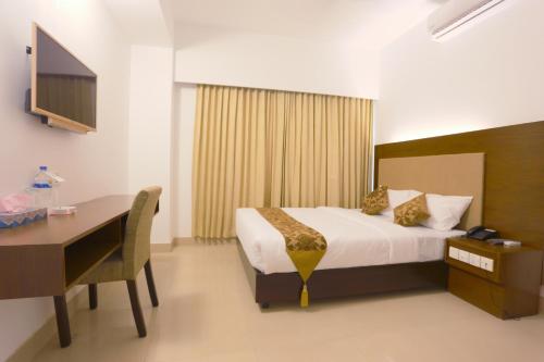 Habitación de hotel con cama, escritorio y ordenador en Holy Inn Sylhet, en Sylhet