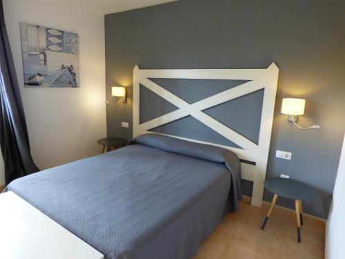 Un dormitorio con una cama azul y blanca y una silla en Casa Julia - OASIS PAPAGAYO, en Corralejo