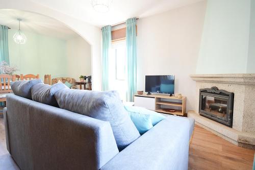 sala de estar con sofá azul y chimenea en A Casa das Camiñas, en Meis
