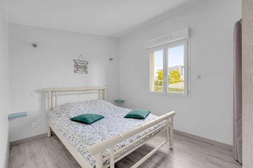 a white bedroom with a bed and a window at LA MEDITERRANEENNE in Quint-Fonsegrives