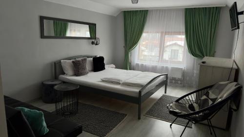 ein kleines Schlafzimmer mit einem Bett und einem Fenster in der Unterkunft Casa Linistita in Chişcău