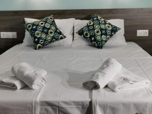 a white bed with towels and pillows on it at Villa Olympia in Paralia Katerinis