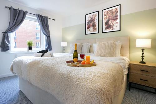 a bedroom with a bed with two bottles of wine on it at City Centre Apartment with Free Parking, Balcony, Super-Fast Wifi and Smart TV with Netflix by Yoko Property in Northampton