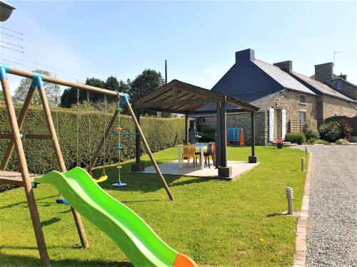 a playground with a slide in the grass at Charming traditional 2-Bed Cottage near Plemet in Plémet