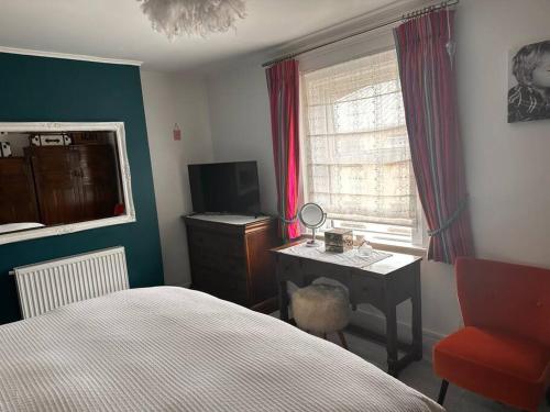 a bedroom with a bed and a desk and a window at Cosy 19th century two bedroomed home with continental Breakfast in Bath