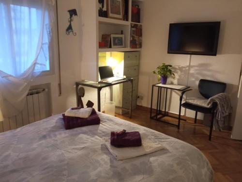 a bedroom with a bed with a laptop and a chair at Warm and well connected in Madrid