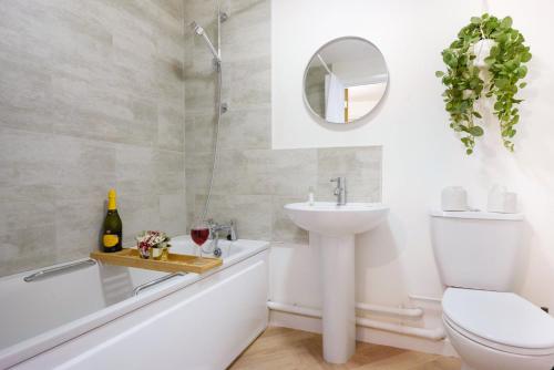 a bathroom with a sink toilet and a tub and a mirror at City Centre Apartment with Free Parking, Balcony, Super-Fast Wifi and Smart TV with Netflix by Yoko Property in Northampton