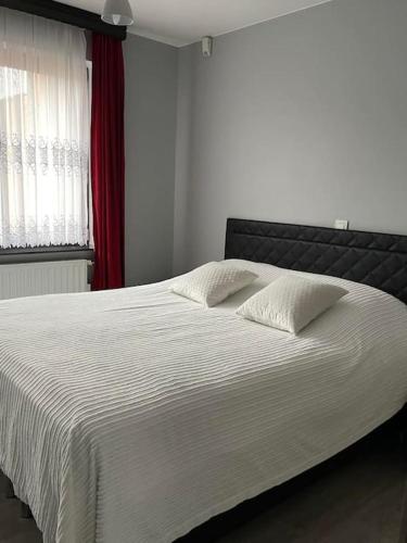 un letto bianco con due cuscini in una camera da letto di SelfmadeHouse ad Asse