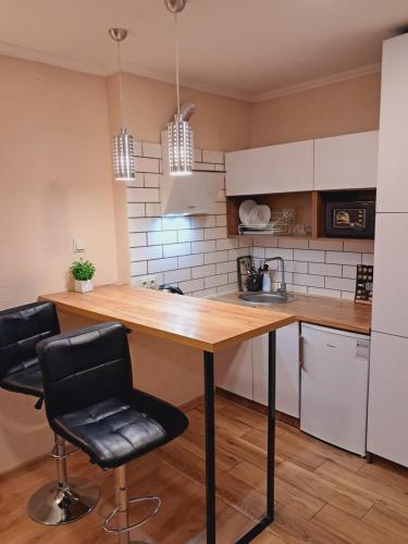 a kitchen with a wooden table and two chairs at New modern apartments in the center in Ivano-Frankivsk