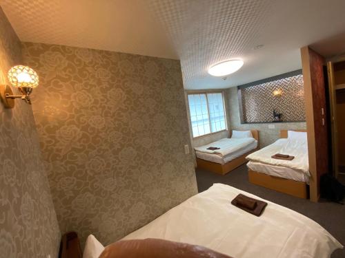 a hotel room with two beds and a window at Allcomein Hotel Akihabara in Tokyo