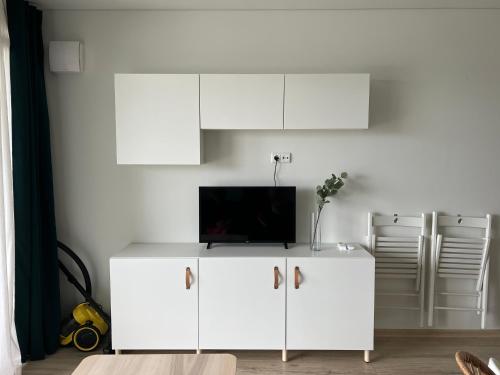 a white cabinet with a tv on top of it at PUŠIS IR JŪRA - Mano Jūra 2 complex - Kunigiškiai in Palanga