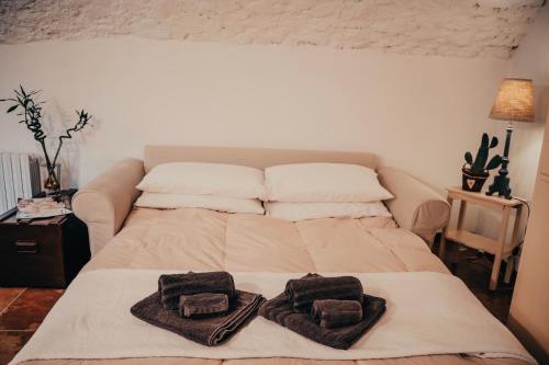 a bed with towels on it in a bedroom at Experience in Valle Varaita - Rustico con SPA Privata - Piscina - Sauna - Hammam - Free Wi-Fi in Brossasco