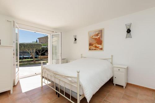 une chambre avec un lit et une grande fenêtre dans l'établissement Superbe Villa Provençale - Piscine - 3 chambres, à Montauroux