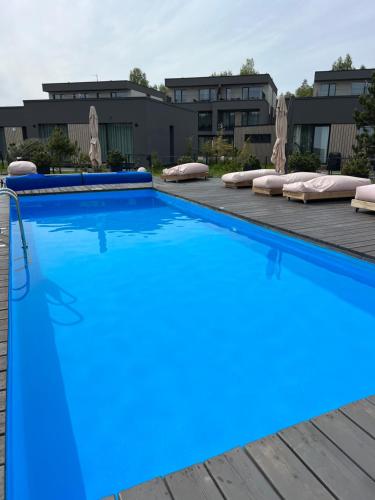 a large swimming pool with blue water in front of a building at PUŠIS IR JŪRA - Mano Jūra 2 complex - Kunigiškiai in Palanga