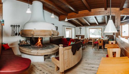 a living room with a fireplace and a dining room at Thurntaler Rast in Außervillgraten
