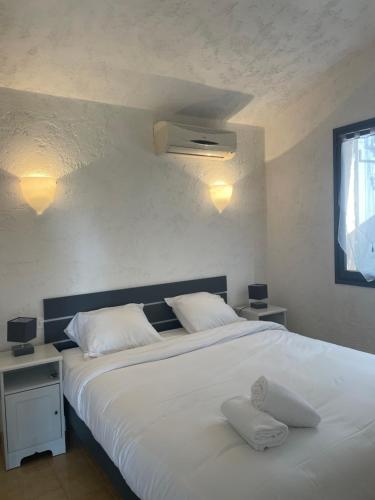 a bedroom with a large white bed with two pillows at Residence "U LATONU" in Porto-Vecchio