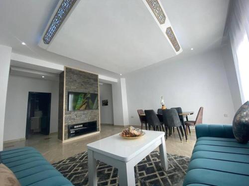 een woonkamer met een blauwe bank en een tafel bij Lovely Seaview beachfront Apartment in Agadir