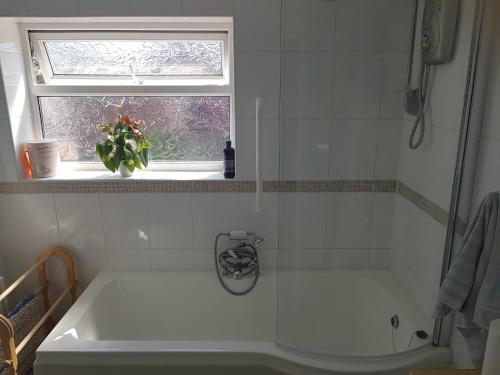 a white bath tub in a bathroom with a window at B&B No. 70 in Southport