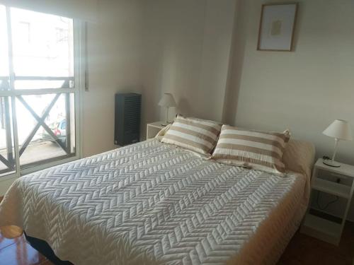 1 dormitorio con 1 cama grande y ventana en Miri House en Bahía Blanca