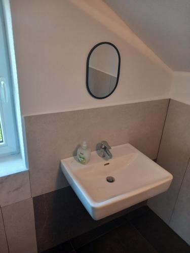 a white sink in a bathroom with a mirror at Casa Marza in Ghioroc